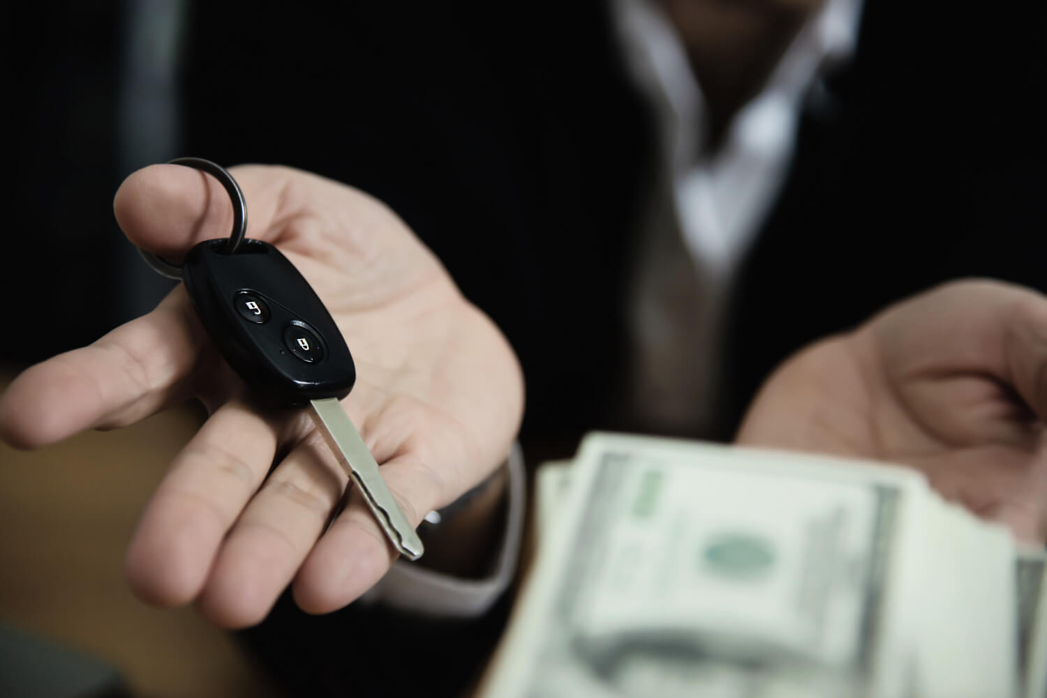 Pessoa segurando chave de carro e dinheiro, representando a diferença entre empréstimo pessoal ou empréstimo com garantia de veículo.